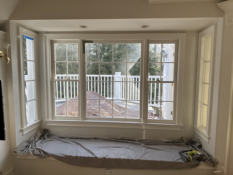 Old wood windows in Norwalk, CT with a window seat below